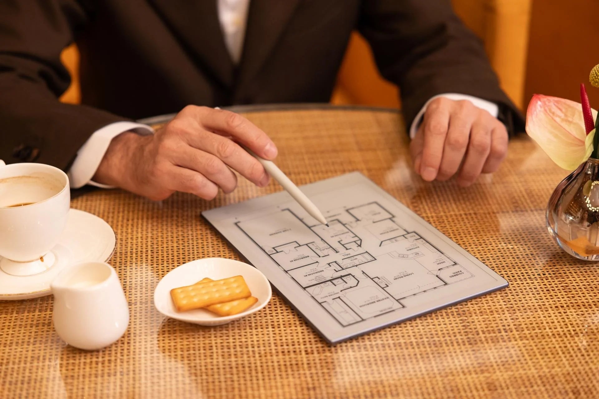Person holding a pen over a map on the viwoods AiPaper with tea and cookies.