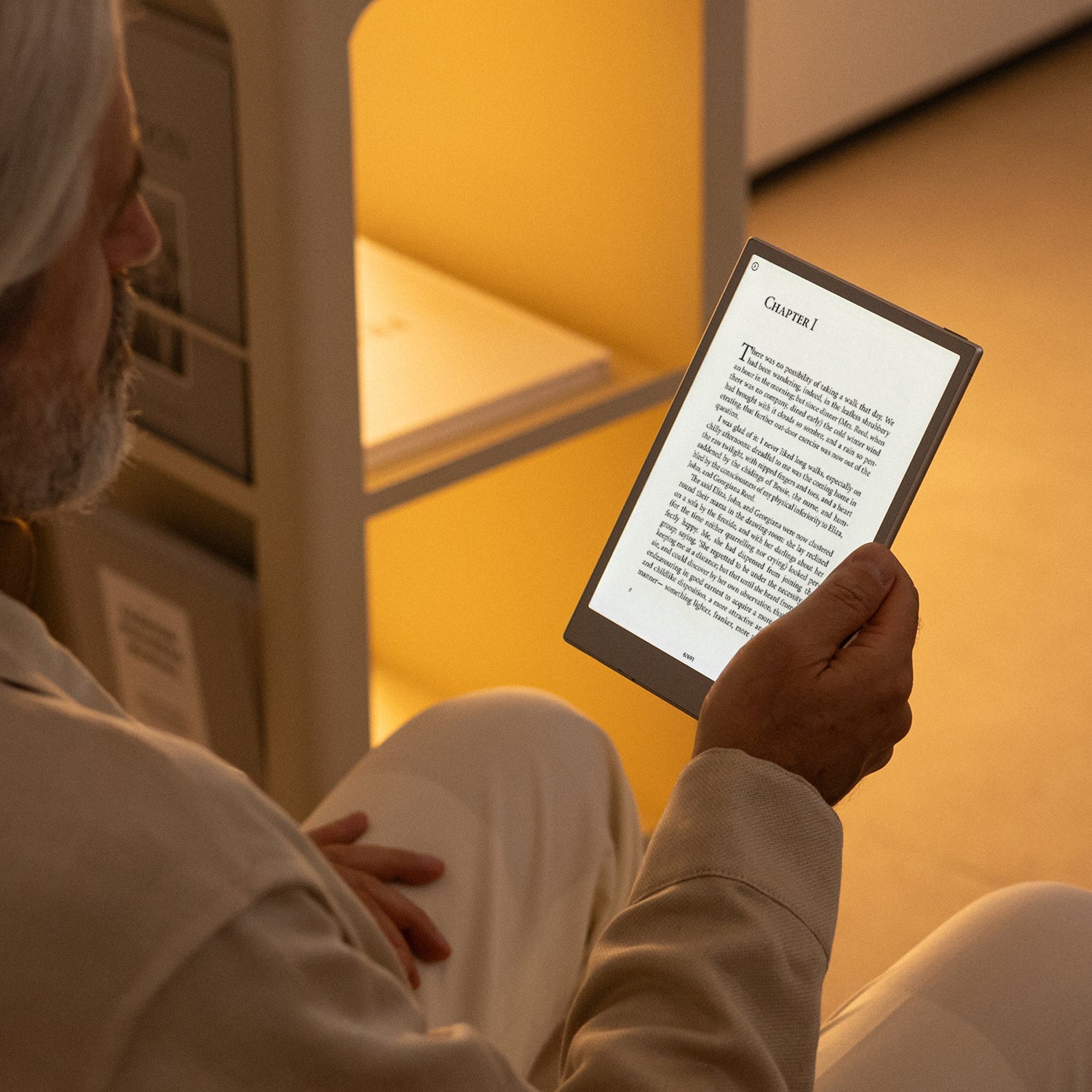 Person reading a document on Viwoods AiPaper Mini in a warm indoor setting